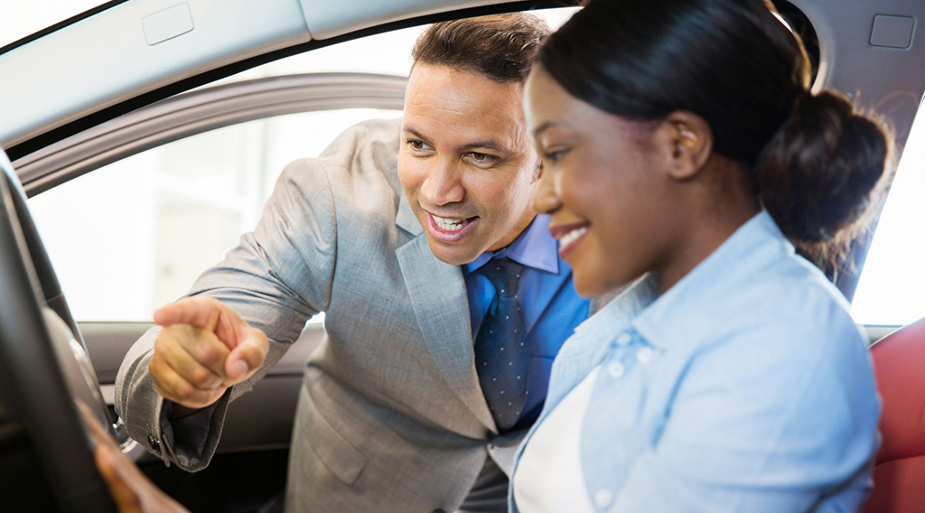 Car sales consultant showing a new car to customer - Michael Jung