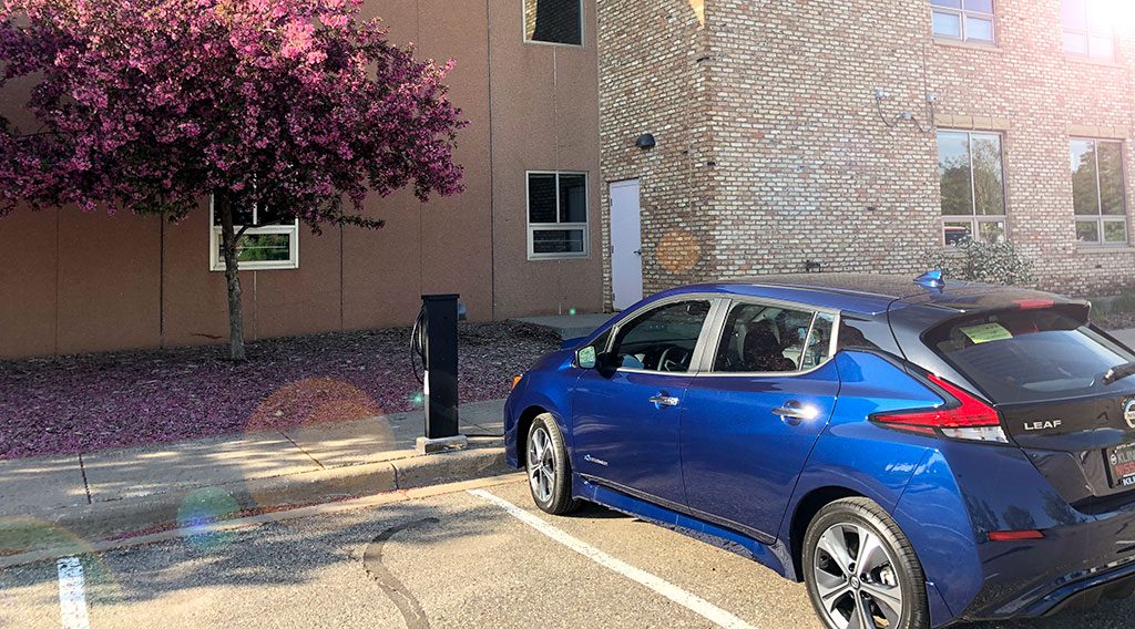 An electric vehicle charging at the greenway building